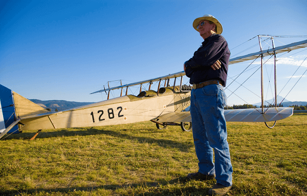 Western Antique Aeroplane & Automobile Museum Founder Terry Brandt standing in front of a Curtis Jenny aeroplane