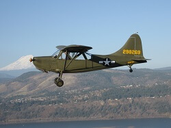 WAAAM's WWII Stinson L-5 flying by Mt. Adams.